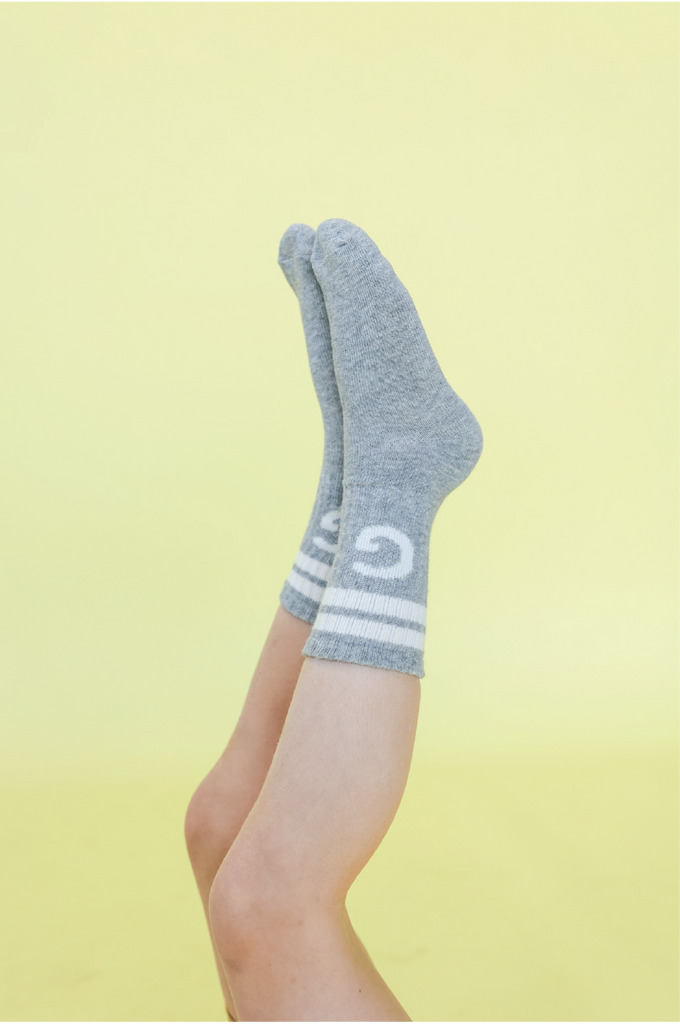 Grey crew socks with white stripes on a yellow background