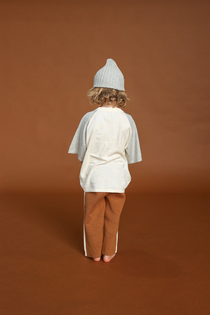 Gray and white tee for children. knitted from organic cotton with brown knitted pant and grey knitted beanie. back view 